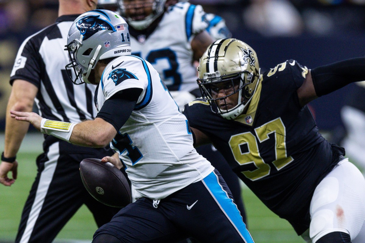 Jan 8, 2023; Carolina Panthers quarterback Sam Darnold (14) scrambles under pressure from New Orleans Saints defensive end Malcolm Roach (97). Mandatory Credit: Stephen Lew-USA TODAY Sports